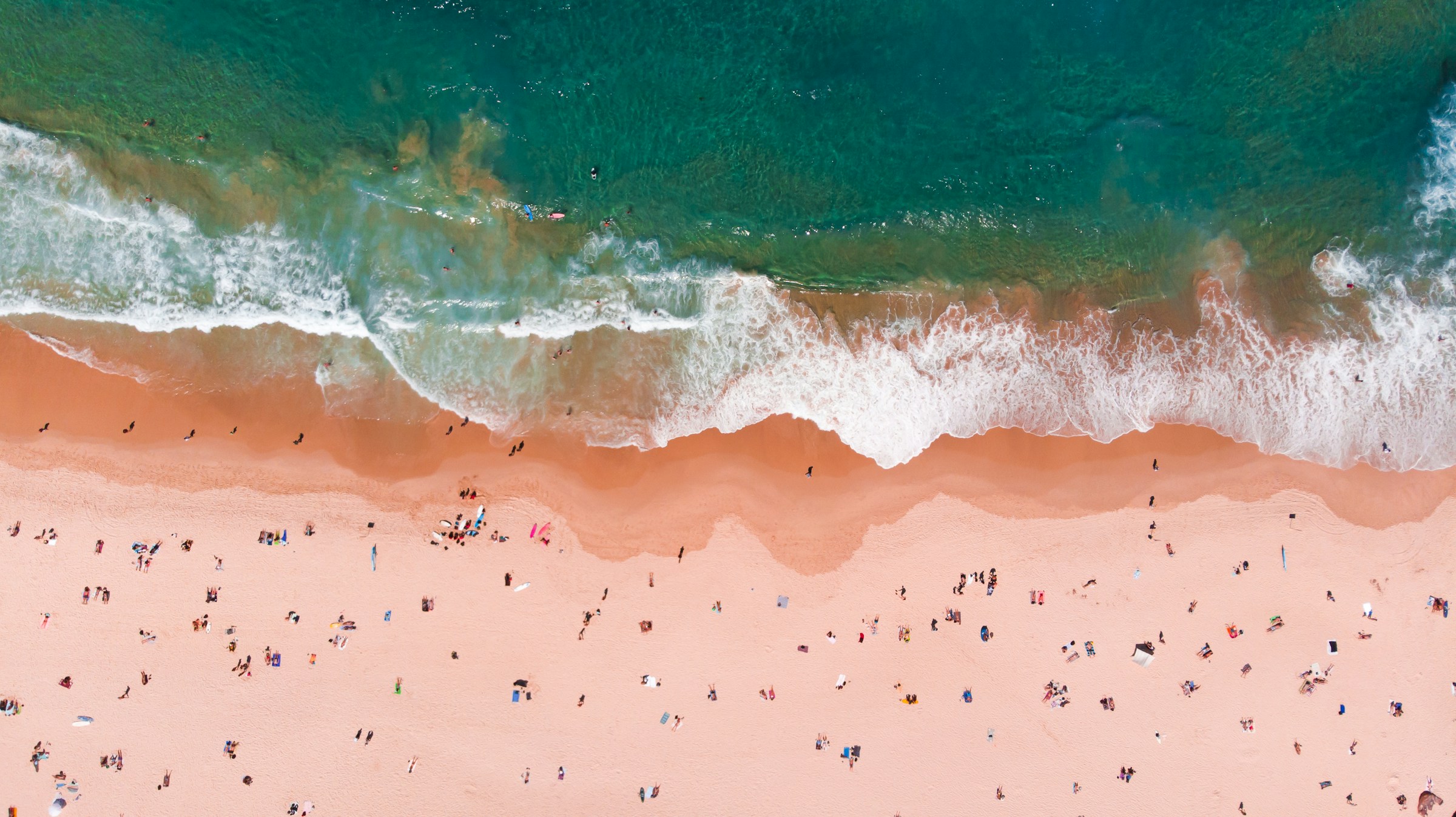 Aerial view of Bondi Beach with turquoise surf breaking on the sand