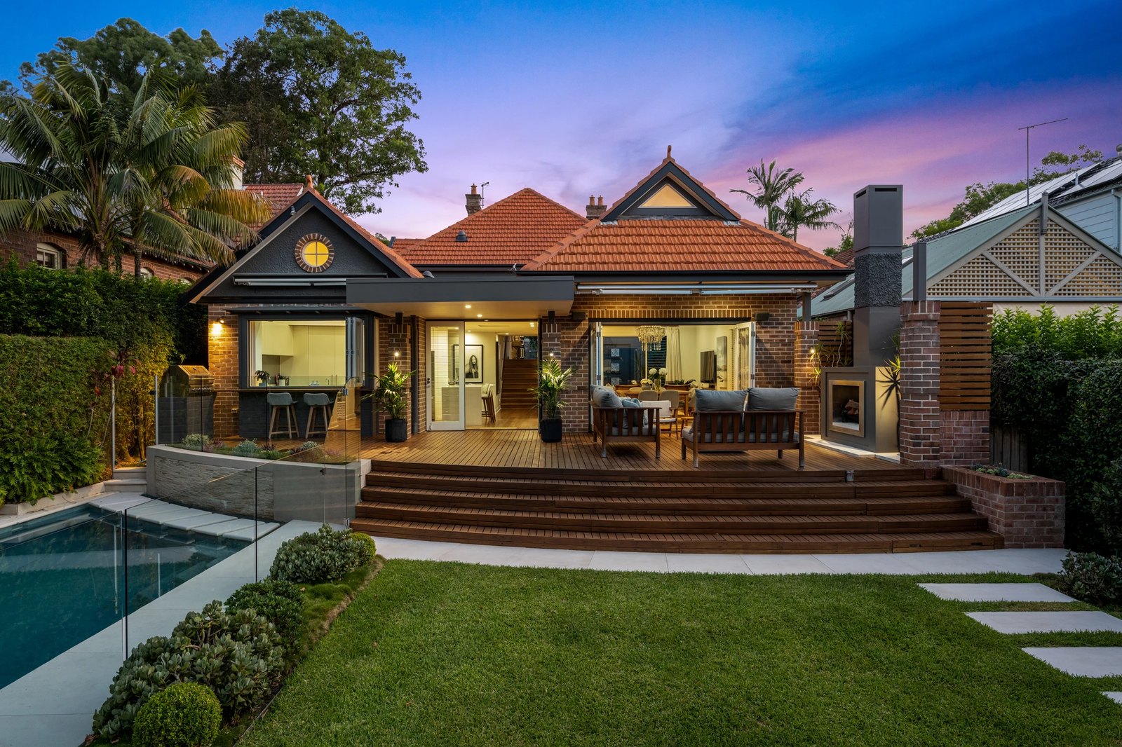 Federation home with a timber deck, lawn and pool at dusk